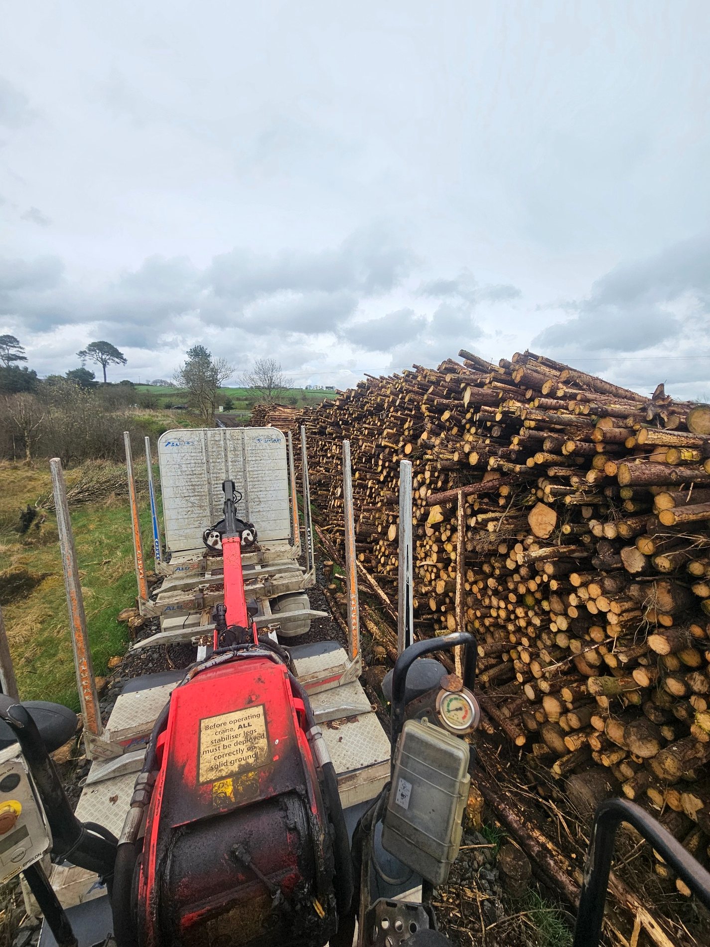 Timber loading view beside stacked logs
